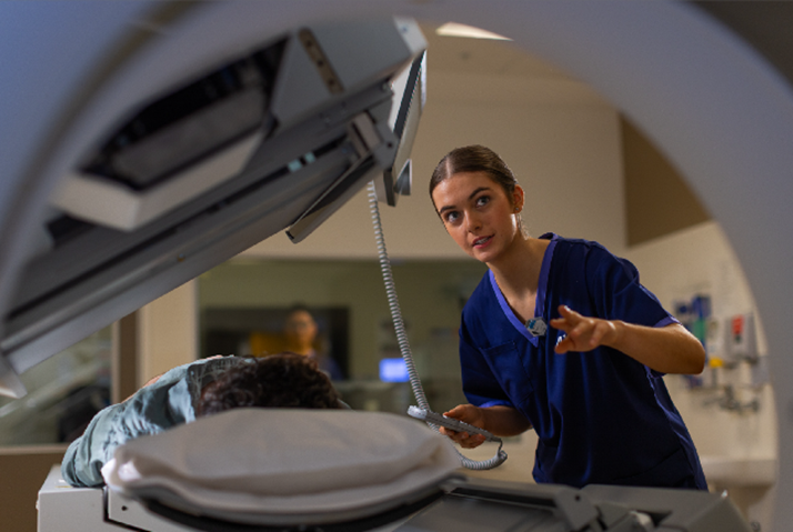 Medical imaging professional using diagnostic equipment in a clinical setting.