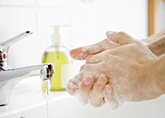 A white male washing his hands with soap