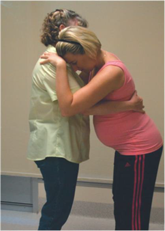 a women resting upright on another during labour