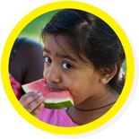 Round photo with a yellow border of a young girl eating watermelon