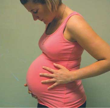 A pregnant woman holding her stomach