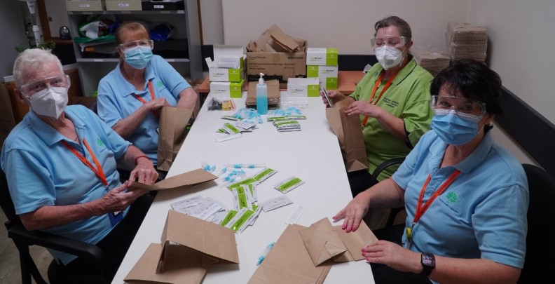 LMVA volunteers from left Marlene Diane Patricia Serena packing Rapid Antigen Tests in the Modbury Hospital basement