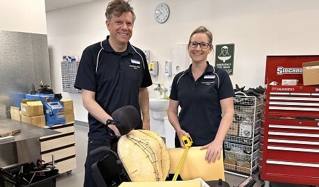Two people in front of robotic wheelchair