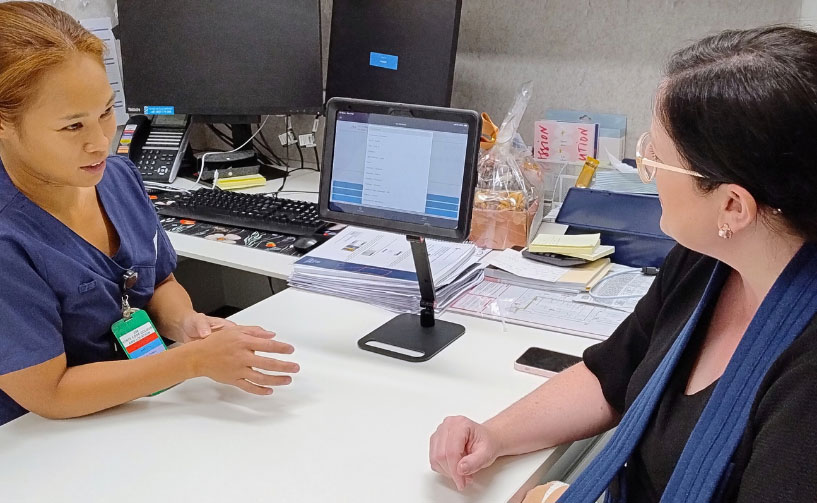 nurse talking to patient in front of computer