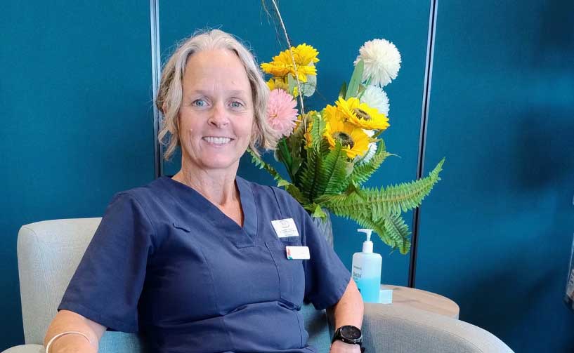 female nurse sitting in front of flowers