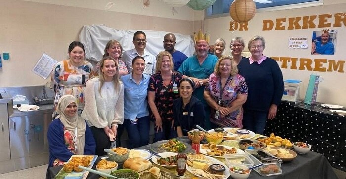 Group of people standing behind a table of food